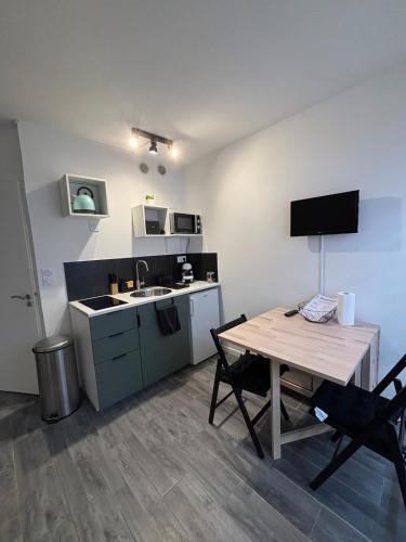 Il comprend une cuisine avec une table et un évier. dans l'établissement Studio équipé pour 2 personnes port olonna, à Les Sables-dʼOlonne