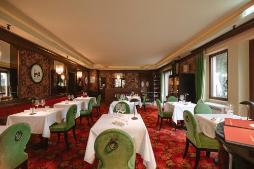 a restaurant with white tables and green chairs at Hotel Miramare in Civitanova Marche