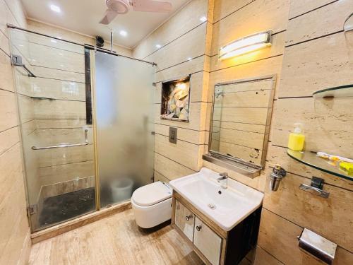 a bathroom with a toilet and a sink and a shower at South Haven Residency - South Extension South Delhi in New Delhi