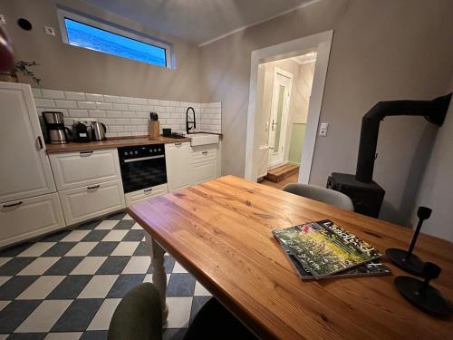 a kitchen with a wooden table with a book on it at Reetdachkate am Deich in Seester