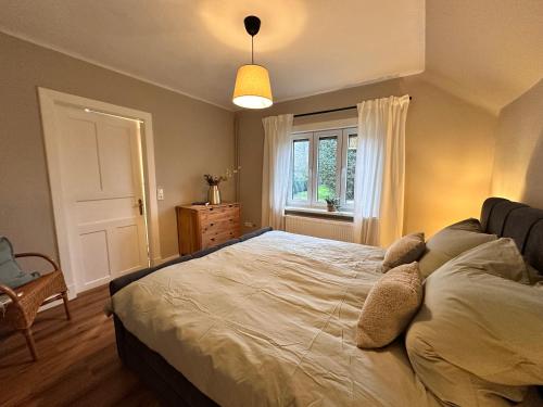 a bedroom with a large bed and a window at Reetdachkate am Deich in Seester
