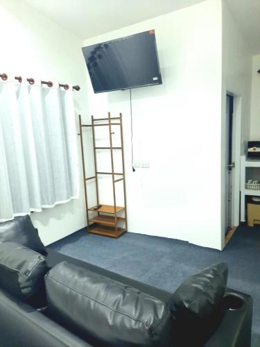 a living room with a couch and a flat screen tv at VicaWorld in Prathai