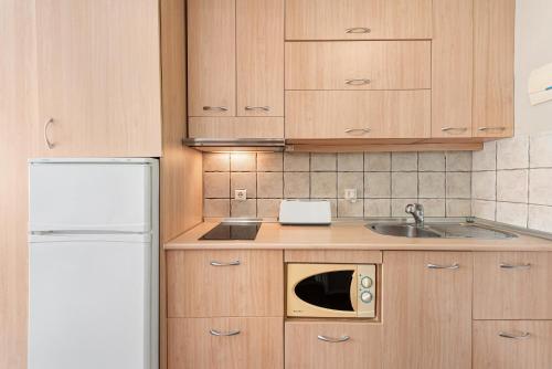 eine Küche mit Spüle und Mikrowelle in der Unterkunft Acogedor estudio en Pedregalejo junto al mar in Málaga