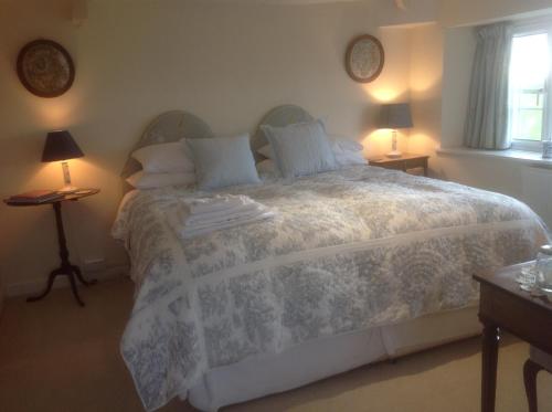 a bedroom with a large white bed with two lamps at The Coach House in Ross on Wye