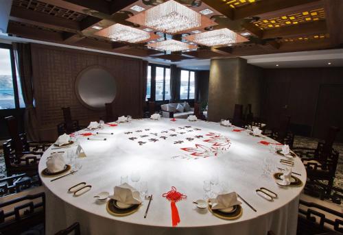 a large white table in a large room with chairs at Hôtel Huatian Chinagora in Alfortville