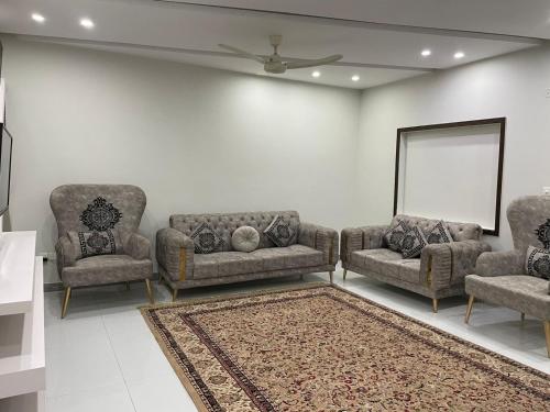 a living room with two couches and a mirror at Comfort Family Villa Islamabad in Islamabad