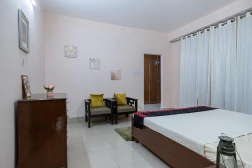 a bedroom with a bed and a chair in it at Kailash Vista in Kalpa