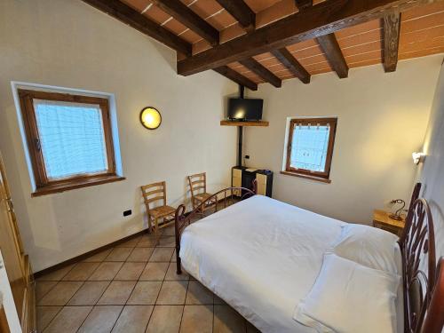 a bedroom with a bed and two chairs in it at Agriturismo L'Urteia in Pieve Dugliara