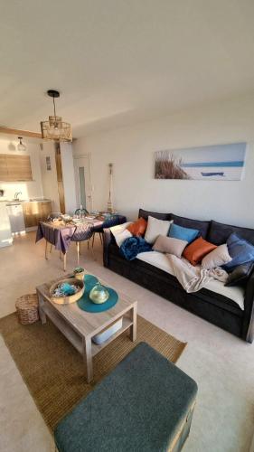 un salon avec un canapé et une table dans l'établissement Au bruit des vagues, vue mer, à Saint-Hilaire-de-Riez