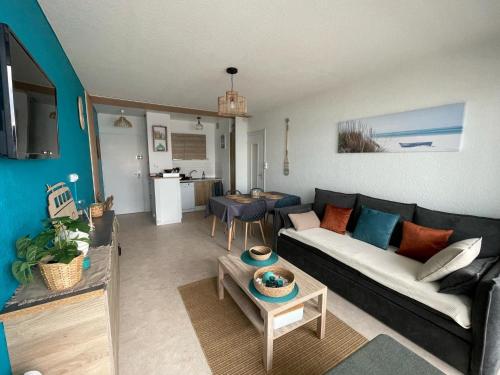 un salon avec un canapé et une table dans l'établissement Au bruit des vagues, vue mer, à Saint-Hilaire-de-Riez