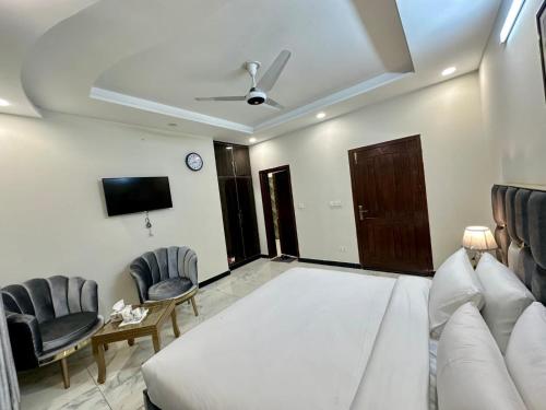 a living room with a bed and two chairs at Comfort Family Villa Islamabad in Islamabad