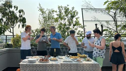 a group of people standing around a table with food at The Den 23 in Maradana