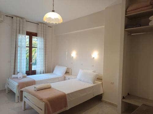 a bedroom with two beds and a chandelier at Molyvos Stars Apartments in Mythimna