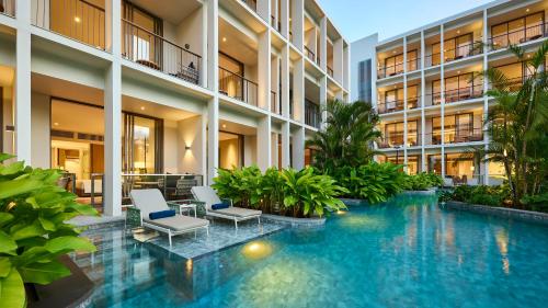 an indoor pool in a building with chairs and plants at Holiday Inn Resort Bintan Lagoi Beach by IHG in Lagoi