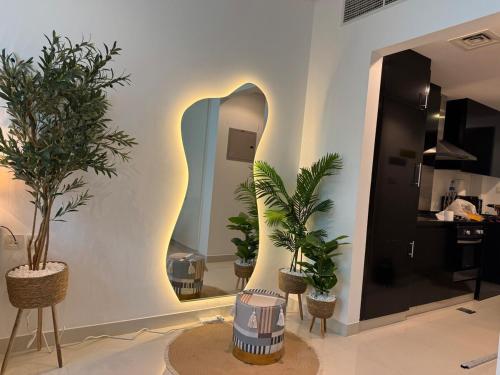 a room with three potted plants and a mirror at ASHRI HH, Bohemian Style Condo in Downtown in Dubai