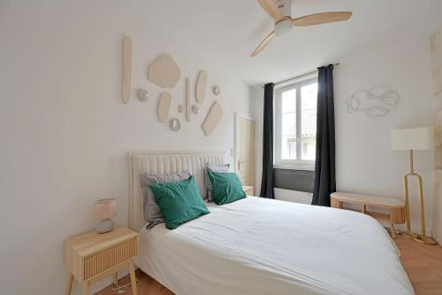 - une chambre avec un lit blanc et des oreillers verts dans l'établissement Le Petit Change - Clim - Hyper Centre, à Avignon