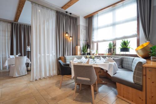 a dining room with a table and a couch at Hotel Gasthof Rössle in Stetten am Kalten Markt