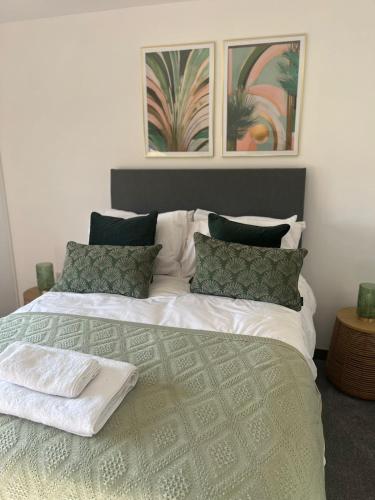 a bedroom with a large white bed with green pillows at Gorgeous 1 bedroom property, close walk to Goodrington beach in Paignton