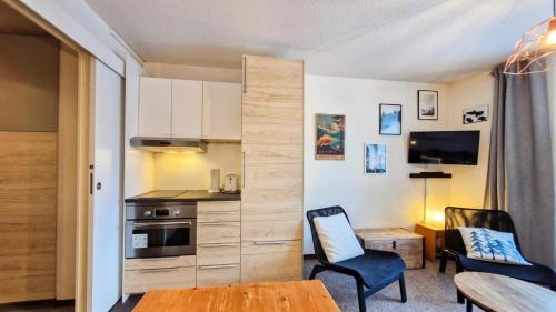- une cuisine avec deux chaises et une table dans une chambre dans l'établissement Résidence Verseau - Appartement lumineux et spacieux · Centre station · avec cabine et Balcon MAE-7781, à Magland