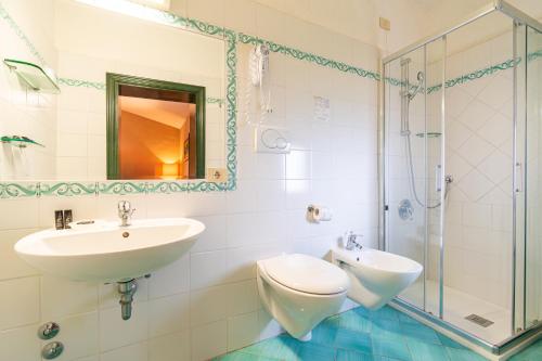 a bathroom with a sink and a toilet and a shower at Hotel Pescille Country House - Tuscany Charme in San Gimignano