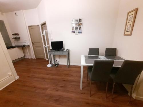une salle à manger avec une table et des chaises blanches dans l'établissement Le Hoche - Apt 4 Personnes, 1 ch, Proche Gare, à Dijon