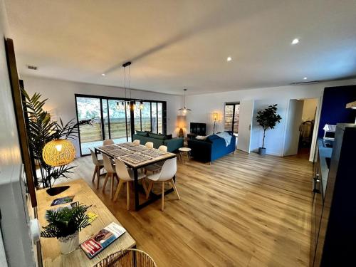 un salon avec une table et une salle à manger dans l'établissement Villas climatisées avec piscine et SPA proche du lac, à Lacanau