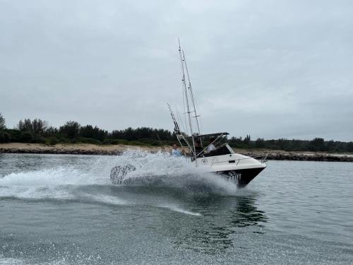 a boat in the water on a lake at Mzingazi Waterfront Accommodation, On The Bay Waterfront Villa's in Richards Bay