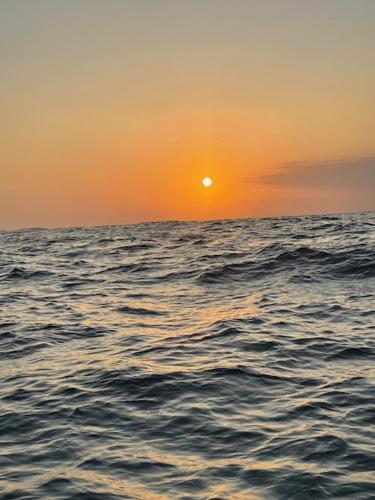 a sunset over a body of water with the ocean at Mzingazi Waterfront Accommodation, On The Bay Waterfront Villa's in Richards Bay
