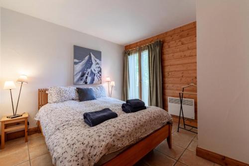 um quarto com uma cama com dois travesseiros em Résidence Bergerie Des 3 Vallees F - Appartement 4 pièces 6 personnes situé dans le charmant village des allues MAE-4991 em Les Allues