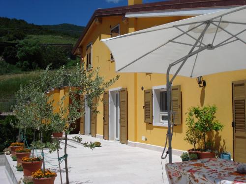 an umbrella in front of a yellow building at Secondo Monolocale Ovest in Dolcè