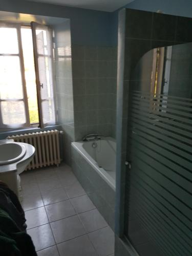 une salle de bain avec une baignoire et un lavabo dans l'établissement La Périgourdine, à Lacropte