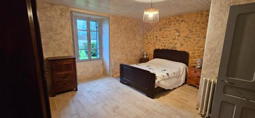 une chambre avec un lit, une commode et une fenêtre dans l'établissement La Périgourdine, à Lacropte