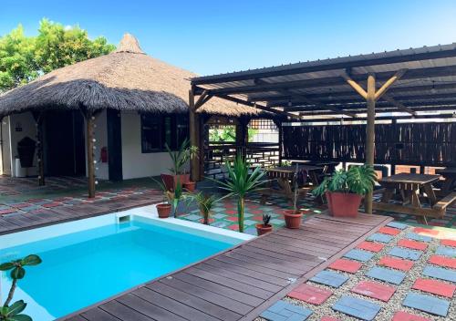 a villa with a swimming pool and a hut at TheLight Villa in Trou dʼ Eau Douce