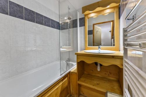 une salle de bain avec un lavabo, une baignoire et un miroir dans l'établissement Résidence Les Hauts De Preclaux - Logement en plein coeur des Orres 1800 MAE-1071, aux Orres