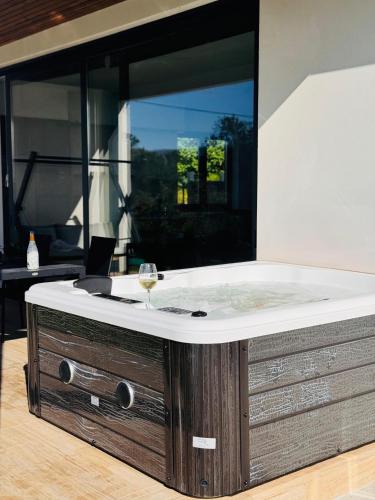 a bath tub with a glass of wine in it at Casa OS BALCÓNS Ría de Arousa in Boiro