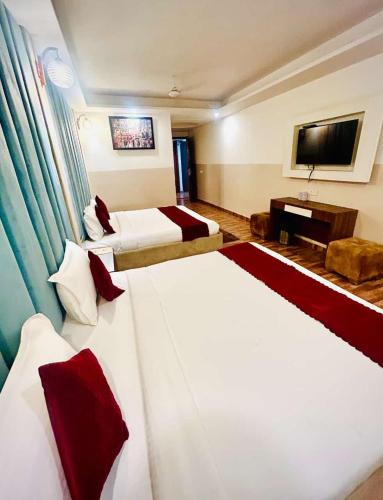 a hotel room with two beds and a television at Hotel Airport City in New Delhi