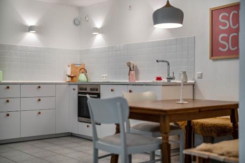 a kitchen with a wooden table and white cabinets at Calm und Cosy direkt am Neckar in Oberndorf am Neckar