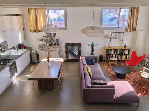 a living room with a couch and a table at Superbe loft avec terrasse et jacuzzi aux Lilas près de Paris in Les Lilas