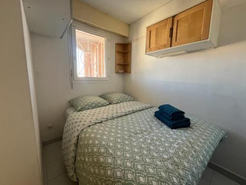 une petite chambre avec un lit et une fenêtre dans l'établissement Le Baïa - Fréjus Plage, à Fréjus