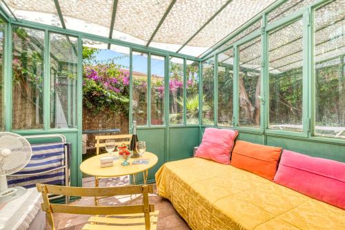 une véranda avec un canapé et une table. dans l'établissement Nice Studio With Garden - Happy Rentals, à Menton