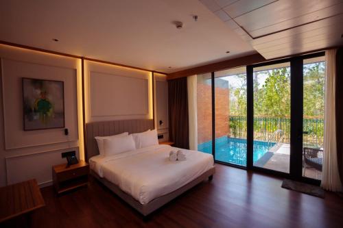 a bedroom with a bed and a swimming pool at Morickap Lord's 83, Trademark Collection by Wyndham in Meenangadi