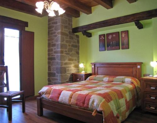a bedroom with a bed and a stone wall at Casa Rural Enarakabi in Zunzarren