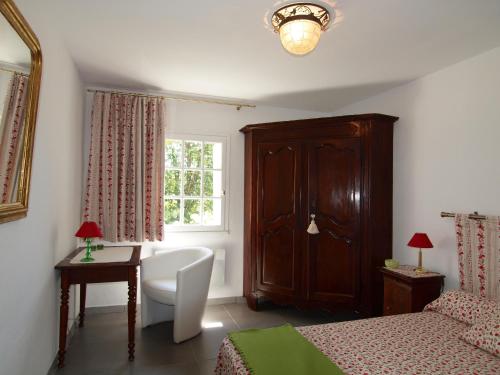 une chambre avec un lit, un bureau et une fenêtre dans l'établissement L'Espaso, à Gailhan