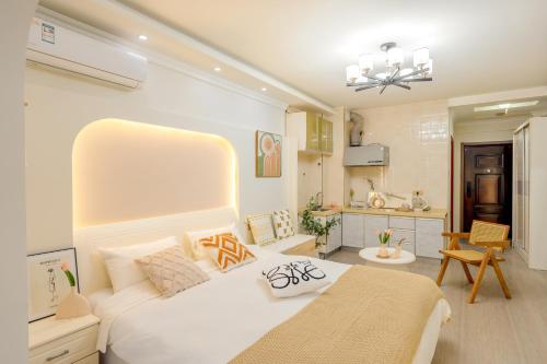 Un dormitorio con una gran cama blanca y una cocina. en Xi'an Hills & Lostwine Boutique Retreat, en Xi'an