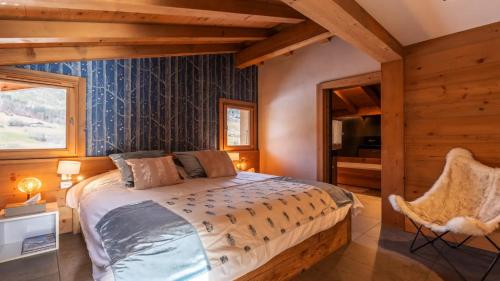 a bedroom with a bed and a chair in a room at Large luxury chalet Megeve in Praz-sur-Arly