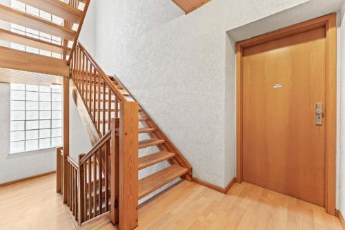 a wooden staircase in a room with a wooden door at Chic Apartment with Parking place in Apolda