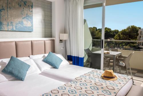 a hotel room with a bed and a balcony at Grupotel Alcudia Pins in Playa de Muro