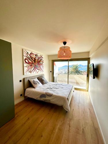 une chambre avec un lit et une grande fenêtre dans l'établissement TOP 3 rooms renovated SEA view 2025, à Cannes