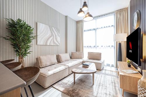 a living room with a couch and a table at Private 1BR Serenity Apartment by Blue Cloud Holidays in Sharjah