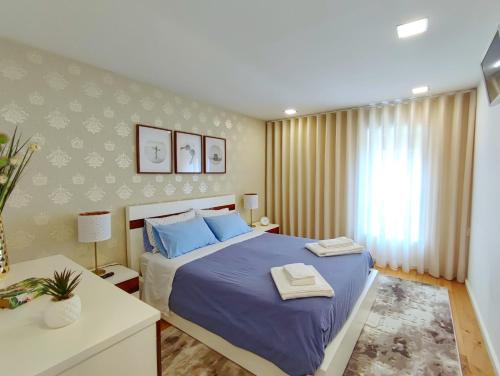 a bedroom with a large bed with blue pillows at Apartamento da Praia - Surf in Matosinhos